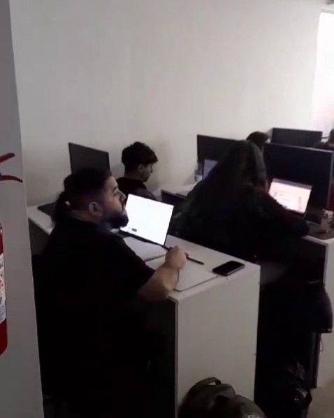 Participantes trabajando en computadores durante un taller de Programa Conversor