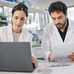 Investigadora trabaja con ChatGPT junto a un colega en un laboratorio universitario