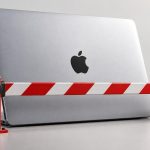MacBook de Apple cerrado detrás de una barrera roja por los permisos de acceso en macOS